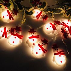 christmas lights with snowmen on them and holly leaves