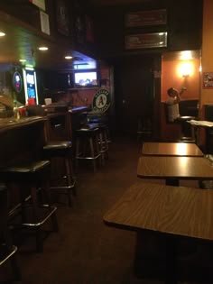 an empty restaurant with wooden tables and bar stools