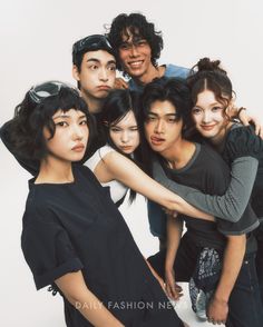 a group of young people standing next to each other in front of a white background
