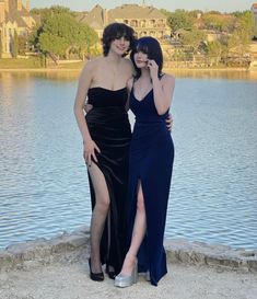 two women standing next to each other near water