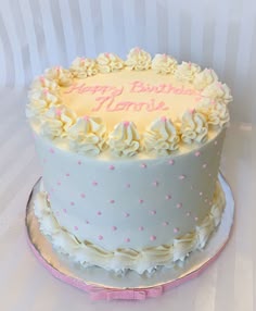 a birthday cake with white frosting and pink decorations