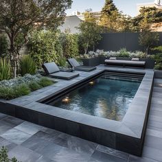 an outdoor swimming pool surrounded by plants and trees