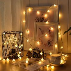 a table topped with pictures and lights next to a cup