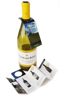 a bottle of wine sitting on top of a table next to an open book and cd