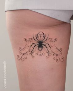 a woman's thigh with a spider tattoo on it