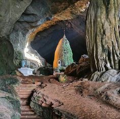 the inside of a cave with stairs leading up to it and a church in the distance