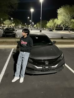 a person standing next to a car in a parking lot