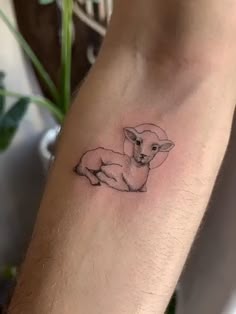 a small lamb tattoo on the arm