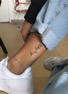 a woman's foot with a rose tattoo on her left ankle and the word love written across it