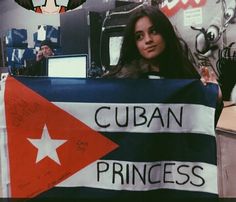 a woman holding up a flag with the word cuban princess written on it in spanish