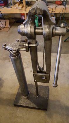 a machine that is sitting on top of a metal stand in a room filled with tools