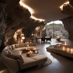 a living room filled with lots of furniture next to a large cave like area covered in rocks