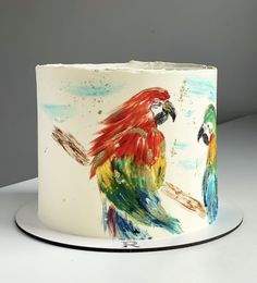 a painted cake with two parrots on it