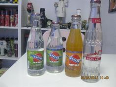 three bottles of soda sit on a counter