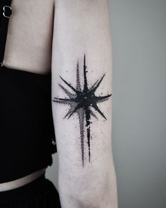 a black and white star tattoo on the arm