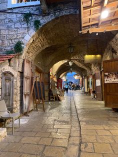 an alley way with people walking down it and shops on both sides, in the background