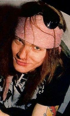 a woman with long hair wearing a pink hat and holding a cell phone in her hand