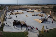 an aerial view of a skateboard park with many people on the ground and ramps