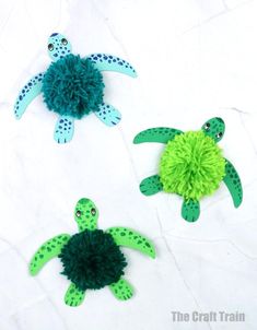 three paper sea turtle decorations on a white surface
