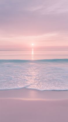 the sun is setting over the ocean with waves coming in to shore and pink sky