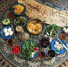 an assortment of food is displayed on a platter with utensils and bowls