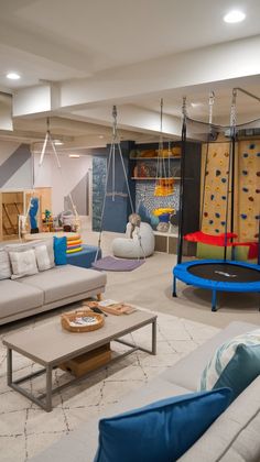 a living room filled with lots of furniture and climbing wall in the backround