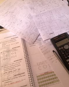 a calculator sitting on top of a table next to some paper with calculations