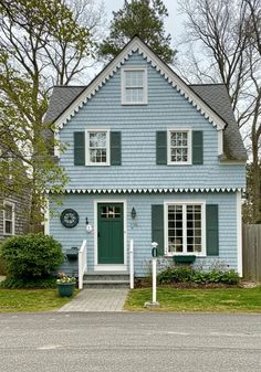 a blue house with white trim and green shutters