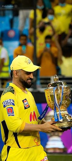 a man in yellow uniform holding up a trophy
