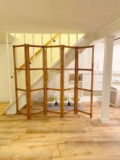 a room divider in the middle of a wooden floor with stairs leading up to it