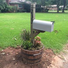 a mailbox sitting on top of a wooden barrel