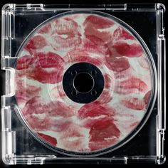 a cd with red lipstick on it in a clear plastic case that is open to show the inside