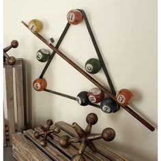 a rack with pool balls and cues on it next to a book shelf filled with books