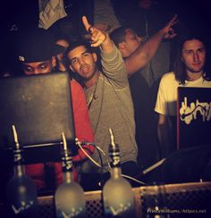 a group of young men standing next to each other in front of a laptop computer