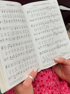 a woman holding an open book with music notes on it
