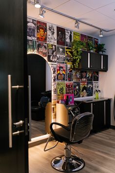 a salon chair sitting in front of a wall with posters on it's walls