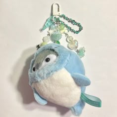 a stuffed animal keychain with a blue bird hanging from it's side