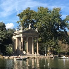 there is a gazebo in the middle of the water with boats floating around it