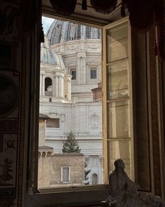 an open window with the view of a building and dome in the backround