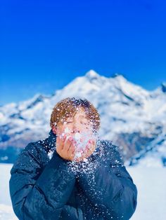 a man standing in the snow covering his face