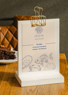 a piece of cake sitting on top of a wooden table next to a clipboard