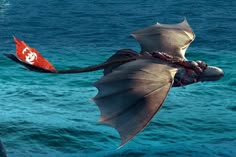 a large bird flying over the ocean