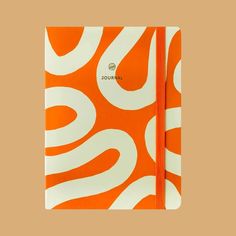 an orange and white spiral notebook with the word journal written on it