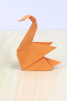 an origami bird sitting on top of a wooden table