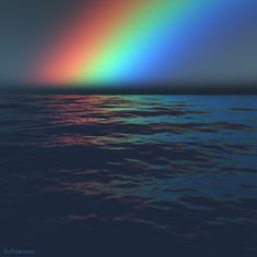 a rainbow is seen over the ocean at night