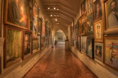 a long hallway with many paintings on the walls