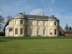 a large yellow building sitting on top of a lush green field