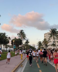 many people are walking down the street on roller skates in front of palm trees
