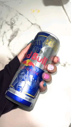 a woman is holding a can of beer in her hand and she has pink nail polish on it