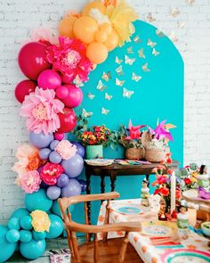 a party with balloons and flowers on the wall is ready to be eaten by someone